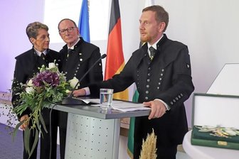 Michael Kretschmer (r.) bei seiner Laudatio auf das Ehepaar Marianne und Prof. Frank-Michael Engel. Im Vordergrund der Sächsische Verdienstorden.
