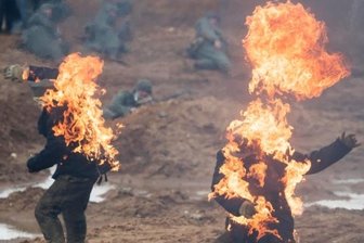 Sie wollen nur spielen - Männer in Nazi-Uniformen gehen in Flammen auf. Ein Russe meint: "Wenn unsere Großväter euch nicht fertiggemacht haben, machen wir euch fertig."