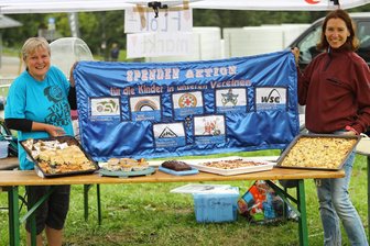 „Sieben auf einen Streich“: Spendenaktion kommt Nachwuchs in Oberwiesenthal zugute - Um Spenden einzunehmen, verkauften Heike Fudel (l.) und Sandra Beyer unter anderem selbstgebackenen Kuchen.
