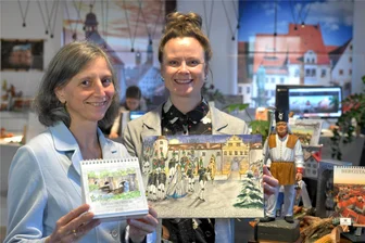 Silberstadtkalender will in Freiberg die Adventszeit versüßen - mit fair gehandelter Schokolade - Ingunn Abraham (l.) hat das winterliche Bild für den Kalender gezeichnet, hier mit Babett Erler vom Tourismus-Team.