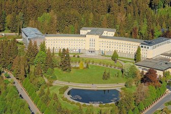 So geht der 6,5 Millionen Euro teure Ausbau an der Klinik Erlabrunn voran - Diese Drohnenaufnahme vom Herbst 2022 zeigt den bereits aufgestockten Nordflügel (r.) auf das Höhenniveau des Haupthauses und den noch eingerüsteten Südflügel, bei dem jetzt der Innenausbau läuft.