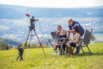 So gelingen himmlische Fotos: Astro-Fotograf aus Aue verrät seine Tricks - Tino Fanghänel hat sein Sonnenteleskop auf dem Spiegelwaldplateau aufgebaut und erläutert, wie eine Aufnahme entsteht. Hier mit Michele Koch (l.), ihrem Sohn Aleo und Lilly Krauß.