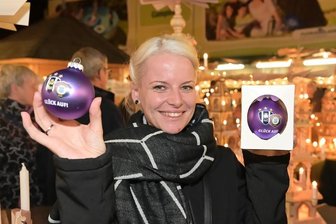 So sieht die neue FCE-Weihnachtskugel aus - Besucherin Romy Lorenz aus Oelsnitz hält die neue FCE-Weihnachtskugel in Händen.