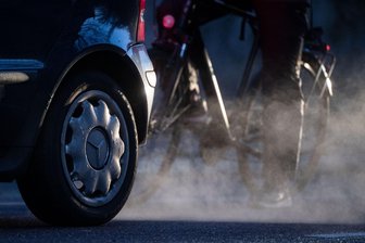 So viele alte Verbrenner sind noch in Sachsen unterwegs - Radfahrer in den Dieselqualm eines Kleinwagens: Diese Abgase möchte niemand einatmen.