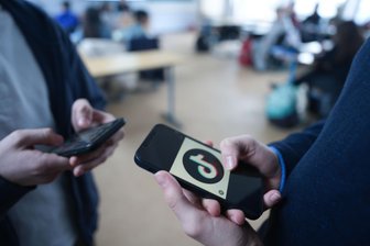 Social-Media-Verbot für Kinder? Gesprächsabend in Plauen zum Pro und Kontra - Schüler stehen in einem Klassenraum und schauen auf ihre Smartphones.