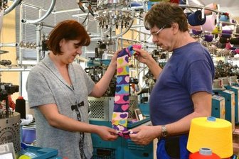 Socken aus dem Erzgebirge: Mit Herzen und Ökosiegel - Programmiererin Helena Alexandrova und Anlagenmechaniker Michael Gruner kontrollieren die Fertigung.