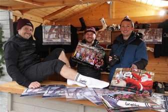 Socken-Kalender feiert beim Weihnachtsmarkt Premiere - Die Kalendermacher Ronald Haß, Bürgermeister Thomas Hetzel und Markus Pfeiffer (von links) mit ihrem Produkt im Verkaufsstand.