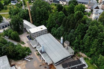 Solar-Boom: Firma aus Aue verbaut tausende Fotovoltaik-Module im Erzgebirge - Das Eisenwerk Elterlein aus der Vogelperspektive. Das Hallendach in der Mitte ist für die Aufnahme der Solarmodule vorbereitet, zu erkennen an den silbrig schimmernden Montageschienen. 