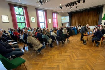 Solar-Protest auch im Schützenhaus: Warum Lengenfeld nun einen Anwalt braucht - Vor der ins Lengenfelder Schützenhaus verlagerten Ratssitzung. Der Andrang war groß, es wurden sogar zusätzliche Stühle herangeschafft. Aufgrund des seit Wochen anhaltenden Protests räumte der Stadtrat den Gästen über die Bürgerfragestunde hinaus Rederecht ein. Bürgermeister Volker Bachmann (stehend) sprach von einem „Sonderfall“.