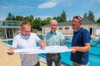 Sommerbad will Sonnenenergie nutzen - Planer Bastian Schneider, Ivo Partschefeld, Sachgebietsleiter im Bauamt der Gemeinde, und Badbetreiber Thomas Sprunk (von links) mit dem Plan für die neue Fotovoltaikanlage im Sommerbad Neukirchen.