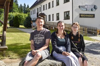 Sommercamp, Handwerk, Industrie: Wo im Vogtland gibt es Ferienjobs? - Ferienlagerleiter Tobias Meyer mit den Betreuerinnen Helena Klöden und Jula Hack (von links) vor dem Haus Reichenbach im Waldpark Grünheide.