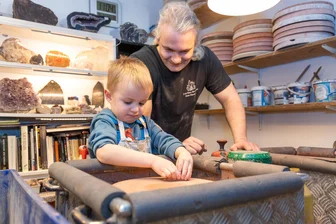 Sommerferien im Erzgebirge: Sechs tolle Abenteuer für Familien unter 40 Euro - Der vierjährige Oskar aus Chemnitz bearbeitet mit Hilfe von René Klausner in Tonis Haus der Steine seine eigenen Edelsteine.