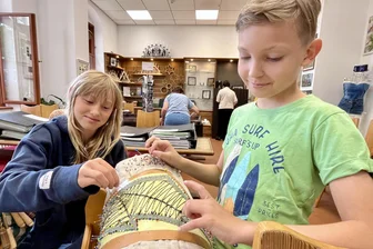 Sommerloch im Erzgebirge: Junge Klöppler fertigen eine Überraschung für Schwarzenberg - Frieda (10) und Rudi (9) beim Abnadeln des großen Drachenflügels.