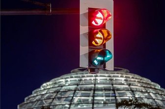 Sondierungsgespräche: Ampelsignal und Abschiedsläuten - Eine Ampel leuchtet in Langzeitbelichtung - im Hintergrund die Reichstagskuppel: SPD, Grüne und FDP sondieren derzeit, ob es für eine Regierungskoaliton reicht. 