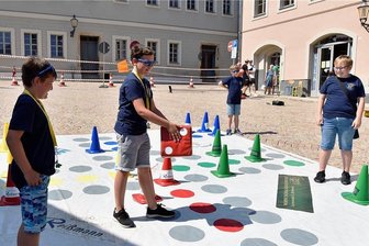 Sonne lacht beim Johannisplatzfest in Reichenbach - Simon, Timmy, Jason und Max (von links) von der Jugendfeuerwehr Reichenbach spielten auf dem Johannisplatz eine Runde Mensch-ärgere-dich-nicht. Das große Spieltuch machte was her. Und die Sonnenbrillen, die es am Stand der Polizei gab, halfen in der gleißenden Sonne. 