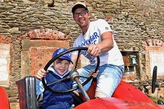 Sound der Entschleunigung in Freiberg-Zug: Mit dem Traktor von Cämmerswalde nach Zwickau - Begeisterung beim Traktorentreffen in Freiberg-Zug: Mats mit Vati Tobias Schierz, hinterm Lenkrad beim Trekkerfahrenspielen. 