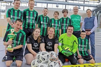 Spaß im Vordergrund hält Team nicht vom Gewinnen ab - Da ist das Ding: Die Fußballerinnen und Fußballer der Lebensbrücke aus Glauchau-Niederlungwitz präsentieren beim Fototermin den Landesmeister-Pokal. Werkstattleiter Jens Naumann und Trainer Gerhard Thriemer (hinten von rechts) freuen sich mit der Mannschaft. 
