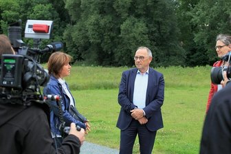 SPD-Chef Walter-Borjans in Zwickau: Weitere Aufarbeitung der NSU-Taten gefordert - Pia Findeiß (links) erzählt Norbert Walter-Borjans und Direktkandidatin Gundula Schubert, wie es zu dem Pflanzen der Bäume kam.
