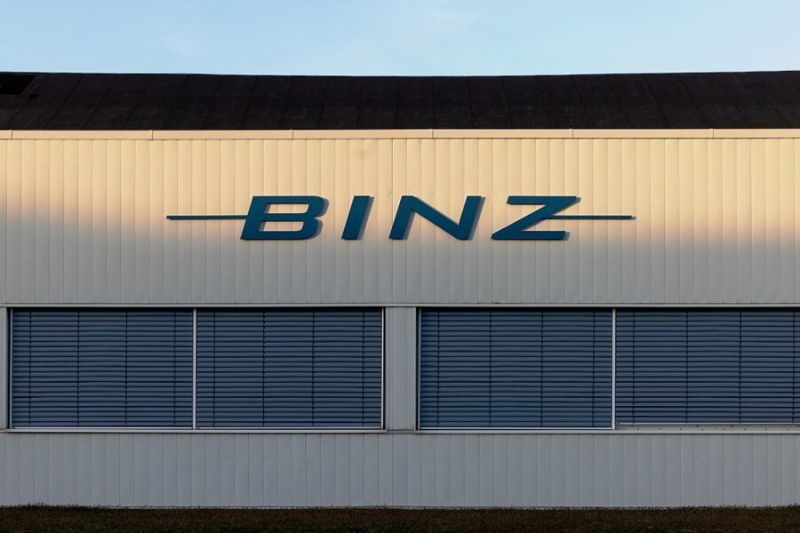 Spezialautohersteller Binz liefert erstmals in Plauen Fahrzeuge aus - Das Logo des Sonderfahrzeughersteller Binz auf einer Werkhalle wird von der Sonne angeleuchtet. Das Thüringer Unternehmen übernimmt das MAN-Werk im sächsischen Plauen. Der Betriebsübergang soll zum 1. April 2021 erfolgen. +++ dpa-Bildfunk +++