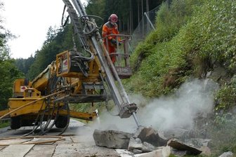 Spezialfirma beseitigt Felssturz-Spuren - Mit einer Bohrlafette wird der mehr als zwei Tonnen schwere Felsbrocken aufgebrochen und in kleine Teile zerlegt.
