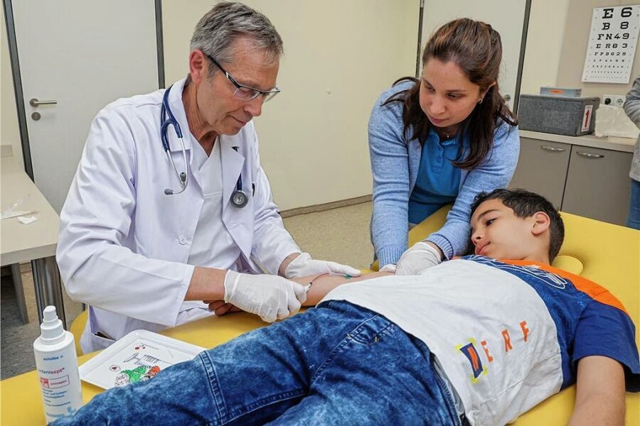 Spezialist für Bluterkrankungen bei Kindern ist zurück in Westsachsen - Harry Sirb nimmt zusammen mit der Schwester Katharina Knorr seinem Kleinen Patienten Yousef Houli (10) Blut ab. Seit dem ersten April gibt es eine Sprechstunde für Kinderbluterkrankungen. 