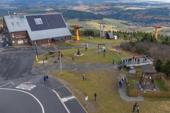 Spiel und Spaß ganz oben in Sachsen: Neues Projekt auf dem Fichtelberg löst Befürchtungen aus - Auf der Wiese links neben der Aussichtsplattform auf dem Fichtelberg soll ein Spielgerät errichtet werden. Die Fläche wird auch als Startbereich für die FIS-Rennstrecke benötigt.