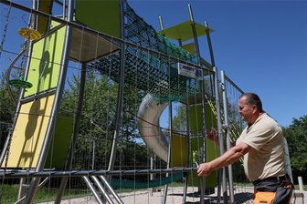 Spielplatzfrust in Schwarzenberg: Vandalen zerstören mit Feuer Netztunnel eines Klettergerüsts - Auf dem Spielplatz an der Lerchenstraße in Schwarzenberg-Sonnenleithe gibt es Vandalismusschäden am Klettergerüst. Hier sichert Maik Neubert von der Spielplatzkontrolle der Stadt das defekte Spielgerät.