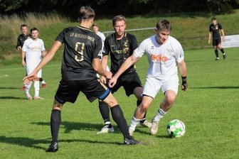 Spitzenreiter lässt nichts anbrennen - Der Zwickauer Nick Krämer (weißes Trikot) wird von zwei Auerhammer Spielern attackiert, lässt sich aber nicht vom Ball trennen.