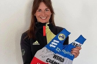 Sport-Podcast "Laktatsachen" mit Julia Taubitz: Darum versteigert sie ihr Olympia-Trikot als Kissen - Julia Taubitz mit ihrem Kissen, das mal ein Sporttrikot war.