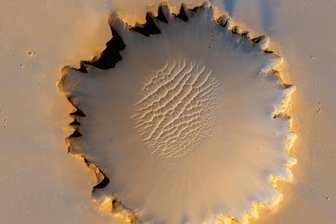 Spuren im roten Staub: 60 Jahre Mars-Missionen - Faszination Mars: Der Victoria-Krater mit einem Durchmesser von etwa 800 Metern war während mehr als 14 der ersten46 Monate des Erkundungsrovers „Opportunity“ sein Heimatgebiet. Er erreichte den Kraterrand erstmals am 27. September 2006. Der Rand weist eine charakteristische gezackte Form auf, die durch Erosion und Abwärtsbewegung des Kraterwandmaterials entstanden ist.