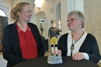 Stadt im Erzgebirge ehrt erzgebirgisches Original - Museumsmitarbeiterin Kerstin Schwertner (l.) und die Neustädtlerin Gerlinde Pfeiffer mit dem Bergmann von Werner Kempf.