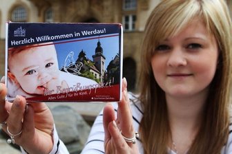 Stadt Werdau heißt Neugeborene auf besondere Art willkommen - Natalie Jung, Auszubildende im Werdauer Rathaus, mit einem Muster des künftigen Babypakets der Stadtverwaltung.