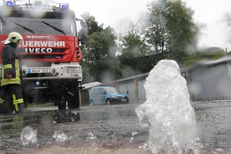 Starkregen: Fontäne aus dem Gully - Feuerwehr sperrt in Schönheide Straße - Im Oberdorf in Schönheide hoben sich nach dem Regen am Donnerstag die Gully-Deckel.