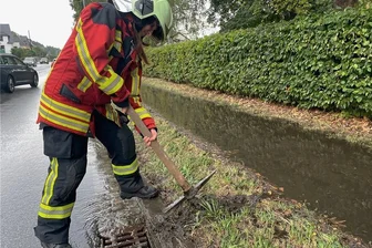 Starkregen über dem Erzgebirge: Feuerwehr rückt in Bad Schlema aus - An der B 169 in Bad Schlema griffen Feuerwehrleute zur Hacke, damit Wasser abfließen kann.