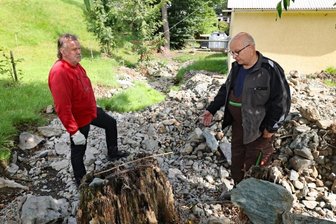 Starkregenschäden in Ruderitz bewegen im Ort die Gemüter - Michael Buntin (rechts) und Uwe Groh stehen inmitten der angespülten Sedimente. Nicht nur in diesem Bereich hat sich das Bett vom Ruderitzbach nach dem Starkregenereignis verändert. Beide hoffen nun auf Hilfe vom Bauhof. 