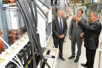 Starkstrom-Gerätebau Neumark: 200.000. Trafo ausgeliefert - Der FDP-Politiker Andreas Schmalfuß (M.) ließ sich 2013 von SGB-Geschäftsführer Wolfgang Keßler (l.) und Fertigungshallenchef Jürgen Walter die Herstellung von Transformatoren, kurz Trafos, erklären.