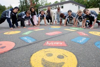 Start frei! Warum Plauener Schüler jetzt 20 Minuten lang für einen guten Zweck laufen wollen - Vor dem Spendenlauf sind alle happy. In der Mitte: Tobias Krebs (l.), Klassenlehrer der 6 a, und Praktikant Toni Wunderlich.