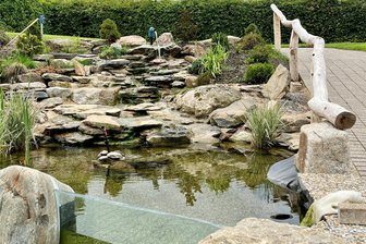 Start in den Freibädern von Raschau-Markersbach mit Neuerungen - Die neue Natursteinkaskade im Freibad Raschau ist ein echter Hingucker. Im Becken tummeln sich kleine Fische.