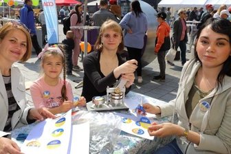 Start in den Mai mit Geselligkeit - Auf dem Auer Altmarkt wurden am Sonntag auch Anstecker für den Frieden gebastelt. Die kleine Nastja und ihre Mama Ludmilla (l.) sind froh, in Sicherheit zu sein. Jenny Lederer und Lisa-Marie Lorbeer (r.) haben geholfen.
