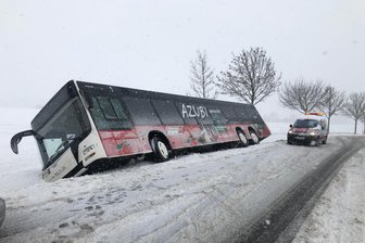 Stau, Unfälle, Schulausfall: Schneemassen bringen Sachsen ins Schwitzen - Bei Frankenberg rutschte dieserBus in den Graben. Die drei Insassen konnten den Bus mit Hilfe von Kollegen eines Abschleppdienstes verlassen. Ein 89-Jähriger wurde leicht verletzt.