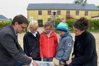 Steinberg-Gemeinde spendiert Grundschule neue Sportanlage - Schulleiterin Sandra Forycki (rechts) und Bürgermeister Andreas Gruner (links) zeigen Merle, Ella und Jonathan, wie die Freiflächen an der Grundschule Rothenkirchen umgestaltet werden sollen. Neben Sportanlagen ist ein neuer Spielplatz geplant.