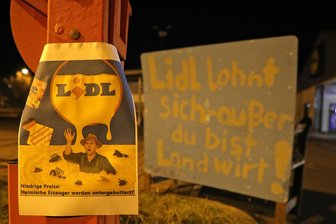 Stinkender Mist vor Lidl in Dresden – geht es um die Butterpreise? - „Lidl lohnt sich - außer Du bist Landwirt!“ steht auf einem Protestplakat.