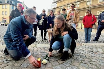 Stolpersteine mahnen in Reichenbach gegen das Vergessen - Im Foto legten Anna-Maria Schmidt und OB Kürzinger am Stolperstein für Arthur Bohm, Marktstraße 2, eine weiße Rose nieder und stellten ein Licht auf.