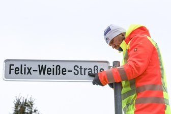 Straße im Erzgebirge bekommt neuen Namen – auf Wunsch von Schülern - Bauhofmitarbeiter Ronny Polze montiert das neue Straßenschild.