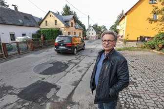 Straßenbau in der Krise: Auerswalder Anwohner frustriert - Gemeinderat und Anwohner Stephan Lazarides steht an der Auerswalder Hauptstraße. Das letzte etwa 2,1 Kilometer lange Stück der Ortsverbindungsstraße zwischen Chemnitztal, Auerswalde und Oberlichtenau ist kaputt und sollte schon längst erneuert werden.