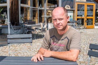 Straßensperrung im Erzgebirge: Gastronomen beklagen massive Umsatzeinbrüche - Jens Wagner sitzt in Deutschkatharinenberg vor der Erlebnisgaststätte Huthaus, die er mit seiner Familie gepachtet hat. Wegen der Baustelle bleiben viele Plätze leer. Das drückt nicht nur den Umsatz, sondern auch die Stimmung.