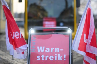 Streik im Busverkehr während Abitur-Prüfungen: Was auf Schüler und Eltern im Erzgebirge zukommt - Ein Schild mit dem Wort Warnstreik steht vor einem Bus: Ab Mittwoch soll auch im Erzgebirge im öffentlichen Nahverkehr gestreikt werden.