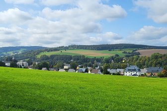 Streit um Solargebiet im Erzgebirge: Warum im Sehmatal nicht alle eine große Freiflächenanlage in ihrem Ort wollen - Die derzeitige Ortsansicht von Cranzahl – noch ohne das geplante Solargebiet. Kritiker des Vorhabens sehen das „malerische Panorama“ in Gefahr. Es würde durch die knapp 23 Hektar große Fotovoltaik-Freiflächenanlage „zerstört“. Unter anderem deshalb wehren sie sich gegen das Vorhaben und wollen ein Bürgerbegehren anstreben.