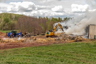 Strohballen-Großbrand im Erzgebirge: Feuerwehrleute noch bis Freitagabend im Einsatz - Schweres Gerät des Technisches Hilfswerks war in Oelsnitz im Einsatz: Die Löscharbeiten des brennenden Strohs dauern an.