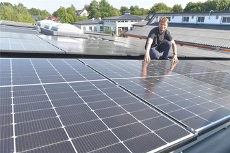 Strom vom eigenen Dach: Diakonie Freiberg nimmt über 500 Photovoltaik-Module in Betrieb - Vorstandsmitglied Georg Rudolph mit den Modulen auf den Dächern der Diakonischen Werkstätten Freiberg.
